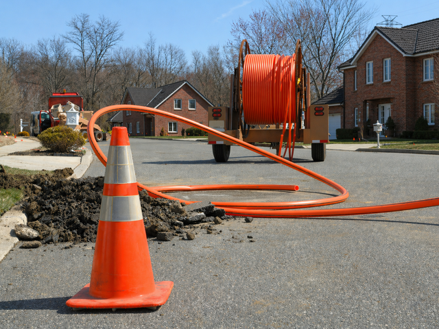 Glasfaserausbau in einer Wohnstraße mit Baustelle und Kabeltrommel.