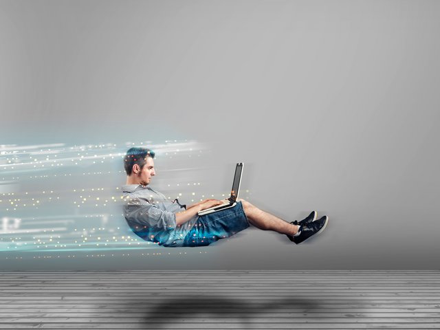Ein Mann arbeitet mit einem Laptop, während leuchtende digitale Datenspuren Geschwindigkeit und eine schnelle Internetverbindung symbolisieren.